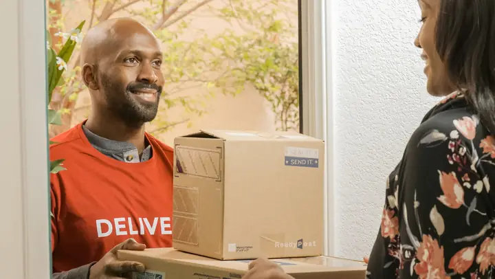 Livreur souriant tenant un colis