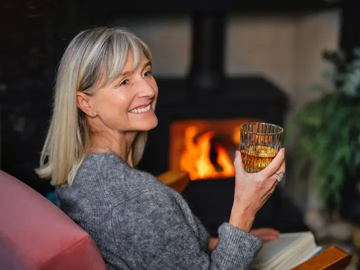 Femme souriante au coin du feu